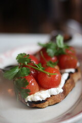 Plated bruschetta with tomato and basil at an upscale restaurant in downtown Minneapolis, Minnesota.