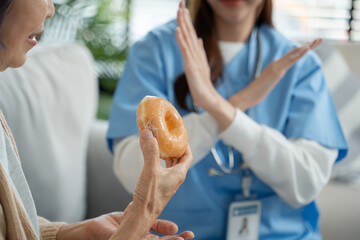 Caregivers rejecting Junk food or unhealthy food such donut sweets to elderly people from eating...