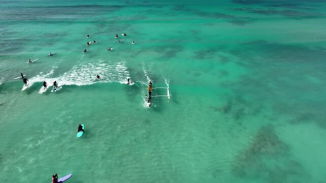 Drone Aerial View of Surfers Riding Waves in Hawaii Sea with Surfboards in the Blue transparent Ocean 