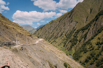 A narrow mountain road in the North Caucasus mountain range. Mountain trail, road collapse, Mountain road construction