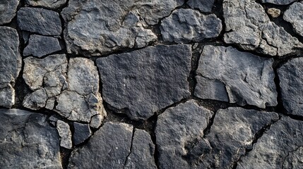 Obraz premium A close-up of the stone wall, with its natural and elegant texture, features rectangular slabs arranged in straight lines to create an overall pattern. The background is neutral gray tones.