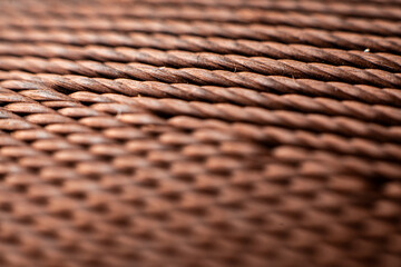 Textured brown fabric showcasing a vintage woven pattern from Asian design traditions