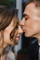 a man and a woman standing very close to each other, their noses almost touching. They look tender and romantic.