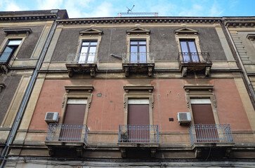 Characteristic Italian facades of tenement houses with balconies in Catania