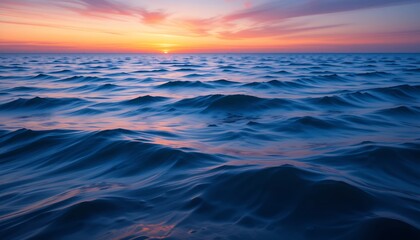 Fototapeta premium Tranquil ocean waves gently rolling under a vibrant sunset sky with soft pastel clouds. Beautiful expanse of sea