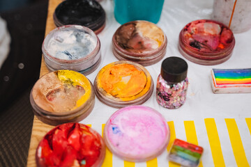 A beautifully arranged table adorned with vibrant face paints and colorful sprinkles, perfect for engaging in creative activities and artistic expression with friends and family