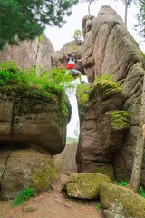 Young man is traveling among large rocks in the rocks
