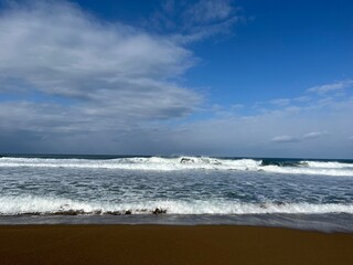 青い空と白い波が美しい海岸の風景
