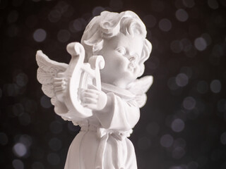 A white angel statue holding a harp