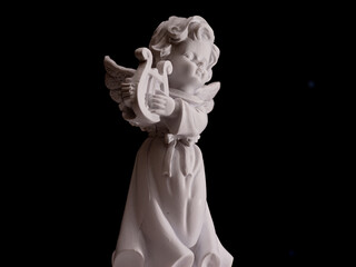 Naklejka premium A white angel statue holding a harp