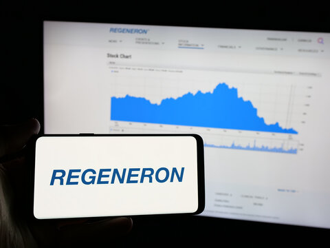Stuttgart, Germany - 01-23-2025: Person holding smartphone with logo of US biotech company Regeneron Pharmaceuticals Inc. on screen in front of website. Focus on phone display.