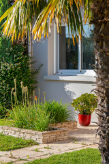 Petit jardin paysagé et ses plantes fleuries au pied d'une maison moderne.