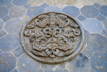 Exquisite round stone carved floor tiles on the street floor of ancient town in China