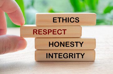 Ethics, respect, honesty and integrity text on wooden blocks with blurred nature background