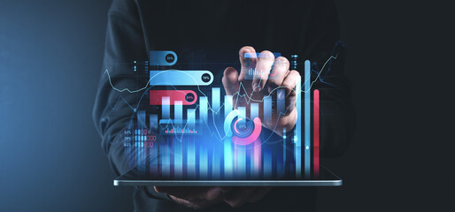 Interactive financial charts and graphs displayed on a tablet device in a dark setting.