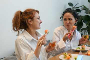 Friends enjoying sushi and drinks at a casual lunch gathering in a cozy restaurant setting