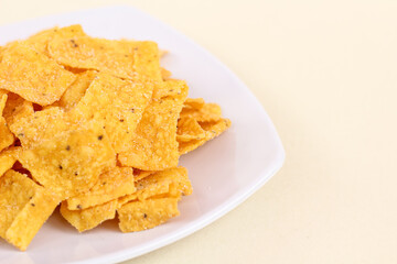 Close up of corn chips served in a plate and isolated on a white background.