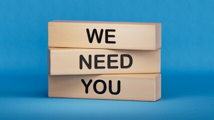 We need you symbol. Concept words We need you on wooden blocks.Business and We need you concept. Copy space.3D rendering on blue background.