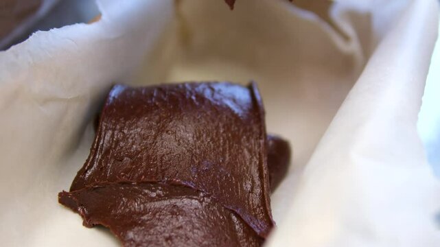 brownie batter chef spreading brownie batter on the tray by scraper