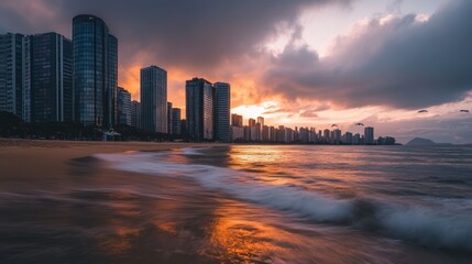 Naklejka premium Dramatic sunset over city skyline and beach.