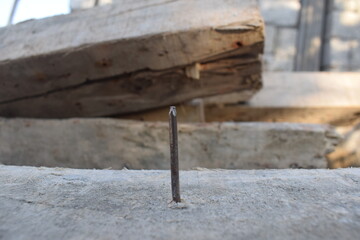 Old rusty nail sticking out of the ground, Broken and defective new metal nail closeup. Bent damaged product. Reject expendable material.