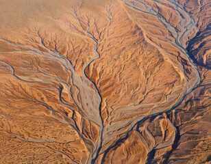 Aerial View of Desert River Networks and Erosion Patterns Under Warm Light