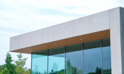 Fototapeta premium Modern architectural design with large glass windows and a minimalist exterior at a serene location