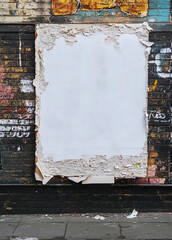 A blank white poster on an A2-format advertising board, standing in the street, dirt and peeling edges. Poster mock up.