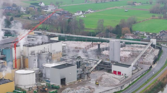 industrial plant factory site oudegem belgium emphasis placed steam rising from recycling paper operations aerial drone panning shot vpk packaging group view 