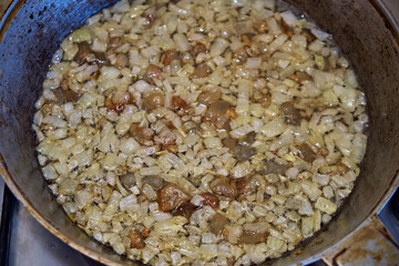 Close-up of fried onions in a frying pan.