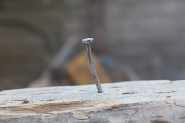  Old rusty nail sticking out of the ground, Broken and defective new metal nail closeup. Bent damaged product. Reject expendable material.