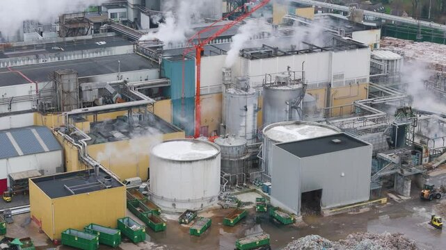 focuses industrial plant factory oudegem belgium steam rising from recycling paper site active processes close up aerial drone panning shot view vpk packaging group 