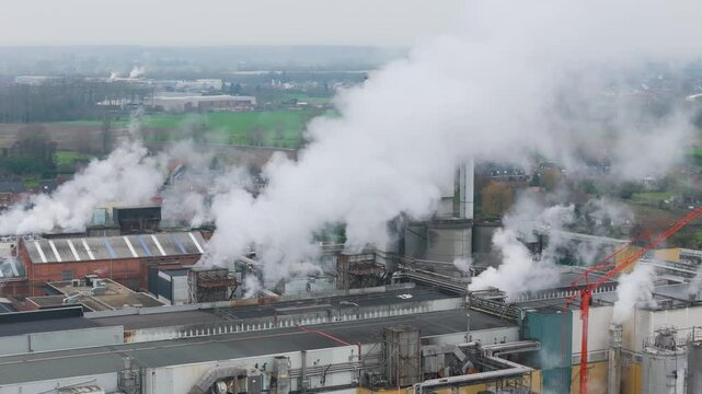 reveals steam rising from chimneys industrial factory oudegem belgium illustrates activity within recycling plant close up forward aerial drone shot view vpk packaging group 