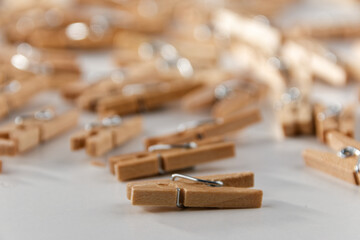 A close-up against a white background of a group of old-fashioned, unsorted wooden clips.