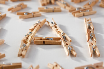 In a close-up against a white background, a group of old-fashioned wooden staples form the word...