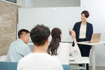 シニア向けのセミナーをする女性ビジネスマン