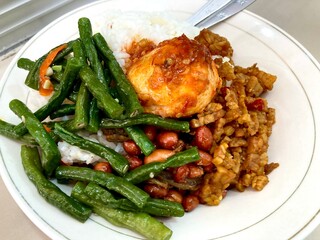 A plate of Indonesian dish called nasi campur or nasi rames, a common dish in Java