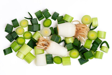 Top view spring onions, leaves and roots on white background.