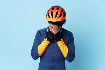 Venezuelan cyclist man isolated on blue background with tired and sick expression