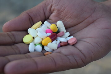 medicine on hand, Woman holding colorful antidepressants on light blue background, top view, Hand holding medicine in blister 