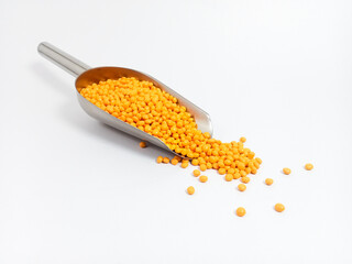 Orange plastic masterbatch, polymer carries colorful pigments with small scoops poured into a white background, suitable for product catalog design of industrial plastic manufacturing company profiles
