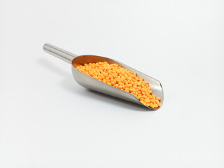 Orange plastic masterbatch, polymer carries colorful pigments with small scoops poured into a white background, suitable for product catalog design of industrial plastic manufacturing company profiles