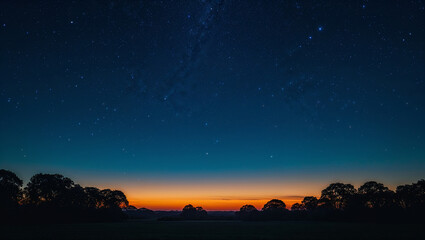Naklejka premium Vibrant sunset filling sky with orange glow under milky way and stars