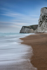 Beautiful atmospheric landscape image of rock arch and cliffs on Jurassic Coast in England during Winter sunset