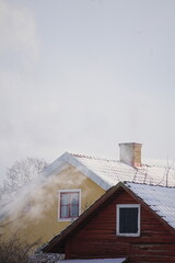 Snow covered house smoke around