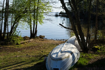 Boats flipped upside down on land near lake