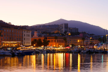Obraz premium Pleasure yachts and fishing boats moored in old port of Ajaccio, the capital of Corsica island, France. Night photo