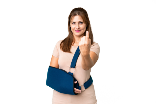 Middle age with broken arm and wearing a sling over isolated background doing coming gesture