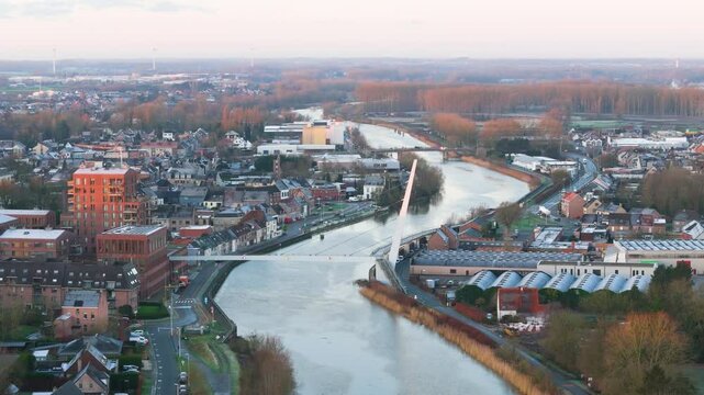city hall bridge over scheldt river wetteren belgium beautifully illuminated by sunrise creating picturesque scene town aerial footage visuals architecture light serenity 