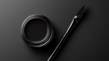 A creamy gel eyeliner jar with its lid off, placed next to an angled eyeliner brush.